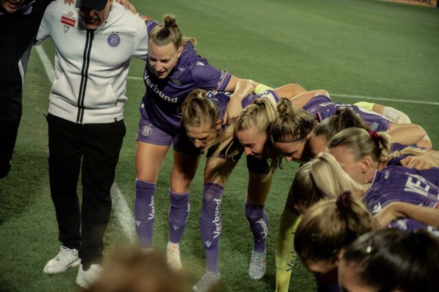 Die violetten Frauen im Kreis vor dem Spiel