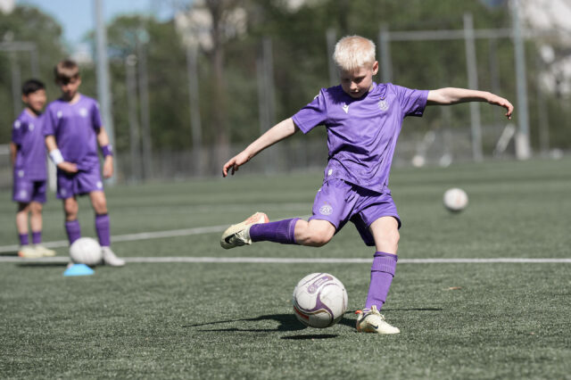 Kind bei einem Camp auf dem Kunstrasen vor der Nord-Tribüne
