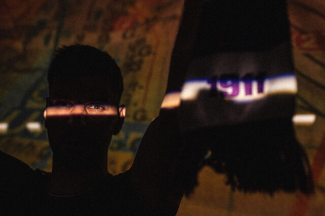 Aleksandar Dragovic im Schatten, sichtbar nur seine beleuchtete Augenpartie