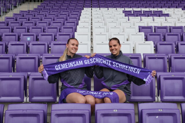 Lena Triendl und Louise Schöffel halten den exklusiven Cup-Schal nach oben