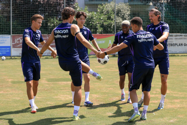 Sechs Spieler bilden einen Kreis und halten den Ball hoch