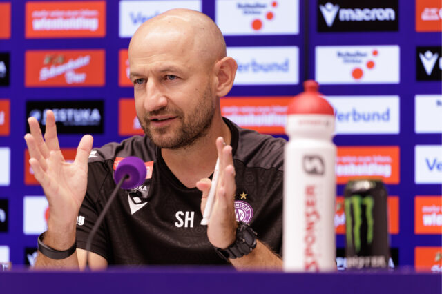 Stephan Helm vor einer Sponsorenwand