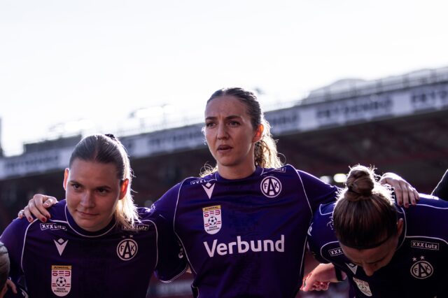 Tatjana Weiss, Modesta Uka und Katharina Schiechtl stehen im Kreis und hören der Ansprache zu