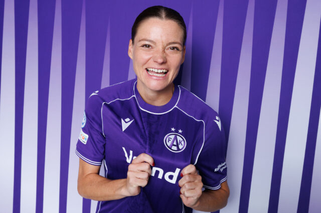 Verena Hanshaw lachend im Austria-Trikot vor violett-weißem Hintergrund