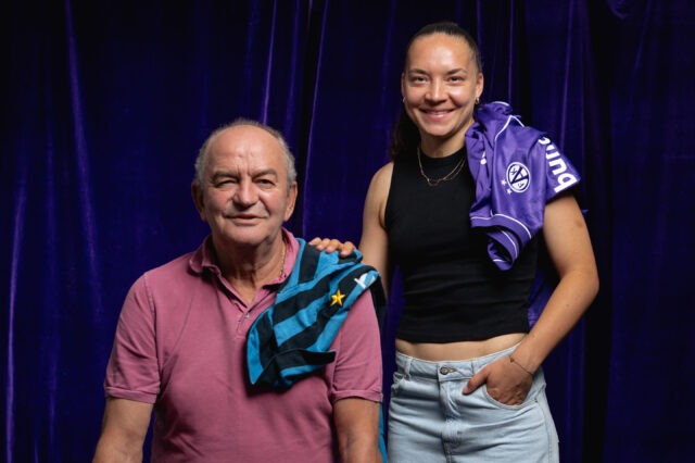 Herbert Prohaska mit einem alten Inter-Trikot und Lotta Cordes mit einem aktuellen Austria-Trikot vor einem violetten Vorhand