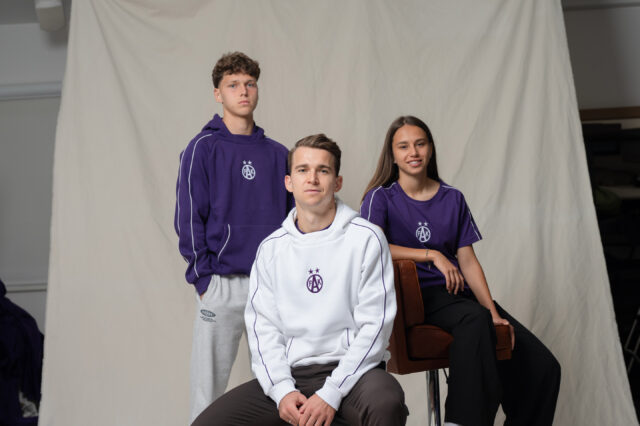 Spieler und Spielerin vor weißem Hintergrund mit neuer Fanshop-Kollektion
